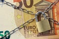 Closeup of 50 euro banknote locked with chain and padlock - Concept of insurance, bail-in and financial security