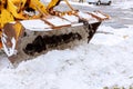 Closeup of excavator for snow removal on a snowy parking lot covered after blizzard Royalty Free Stock Photo