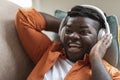 Closeup of excited black guy listeing to music at home