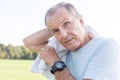 Closeup of exhausted senior man cleaning sweat after workout in park