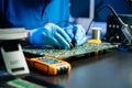 Closeup of expert soldering a green PCB board using precision tools. Ideal for electronics, circuit repair, engineering, tech Royalty Free Stock Photo