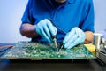 Closeup of expert soldering a green PCB board using precision tools. Ideal for electronics, circuit repair, engineering, tech Royalty Free Stock Photo