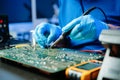 Closeup of expert soldering a green PCB board using precision tools. Ideal for electronics, circuit repair, engineering, tech Royalty Free Stock Photo