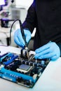 Closeup of expert soldering a green PCB board using precision tools. Ideal for electronics, circuit repair, engineering, tech Royalty Free Stock Photo