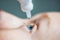 Closeup of eyedropper putting liquid into open eye