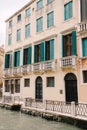 Closeup of the facade of a building, on the streets of Venice, Italy. The four-story building is sand-colored with green Royalty Free Stock Photo