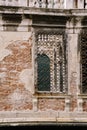Closeup of the facade of a building, on the streets of Venice, Italy. Stone wall texture and wrought iron metal grill. Royalty Free Stock Photo