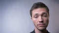 Closeup of face of attractive caucasian man looking straight at camera and waving with his head. Answear no