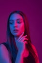 Closeup face of beautiful brunete woman in neon light red and blue