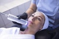 Closeup of face of beautiful relaxing girl undergoing hardware cosmetology procedure in spa