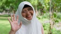 Closeup face of cheerful elderly woman covered with headscarf smiling outdoors. Casual Islamic girl in park. Freedom and relaxing