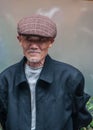 Closeup of face of graying senior man with mairine-blue vest, Shanghai, China