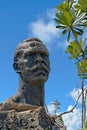 Closeup of a face of a statue against the blue sky