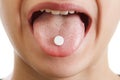 Closeup face of young man taking drug, pill into him mouth Royalty Free Stock Photo