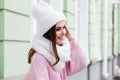 Closeup face of a young Smiling woman enjoying winter wearing knitted scarf and hat. Royalty Free Stock Photo