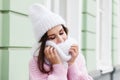 Closeup face of a young Smiling woman enjoying winter wearing knitted scarf and hat. Royalty Free Stock Photo