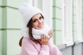 Closeup face of a young Smiling woman enjoying winter wearing knitted scarf and hat. Royalty Free Stock Photo