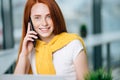 Closeup facial portrait of happy redhead woman on mobile phone call