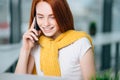 Closeup facial portrait of happy redhead woman on mobile phone call