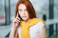 Closeup facial portrait of happy redhead woman on mobile phone call