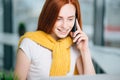 Closeup facial portrait of happy redhead woman on mobile phone call