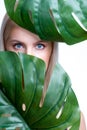 Closeup facial portrait personable woman holding green monstera.