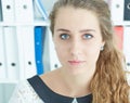 Closeup facial portrait of young attractive Caucasian secretary on office background.