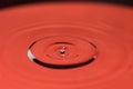 Closeup of falling water drop in red Royalty Free Stock Photo