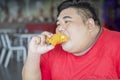 Closeup of fat Asian man eating a fried chicken Royalty Free Stock Photo
