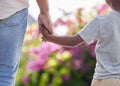 Closeup father and son holding hands while walking outside in the garden. A great role model and mentor for his boy Royalty Free Stock Photo