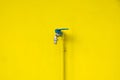 Closeup faucet on concrete Yellow wall background. Water leaking Royalty Free Stock Photo