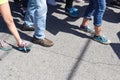 Closeup of feet and legs - People walking on cracked sidewalk with various shoes and pants Royalty Free Stock Photo