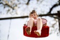 Closeup of feet of little toddler girl having fun on swing in domestic garden. Small child swinging under blooming trees Royalty Free Stock Photo