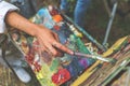 Closeup of female artist hand paint a picture on a palette at workshop, close up top view Royalty Free Stock Photo