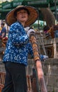 Closeup of female captain of wooden boat on canal in Tongli, China
