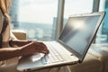 Closeup of female copywriter working on laptop sitting in modern office