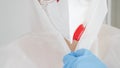 Closeup of female doctor of bacteriologist wearing and putting on protective biohazard suit, glasses, gloves and facial