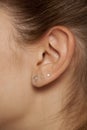 Female ear with three earrings Royalty Free Stock Photo