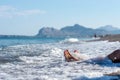 Closeup of female feet with pink pedicure in a foamy sea of a wave Royalty Free Stock Photo