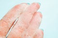 Closeup female fingers in white foam on a blue background Royalty Free Stock Photo