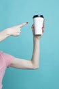 Closeup of Female Girl Hand Pointing with Finger Cup of Coffee Drink Isolated on Vivid Trendy Turquoise background