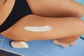 Closeup on female hand applying sunscreen creme on beautiful legs. Skincare. Sun protection sun cream Royalty Free Stock Photo