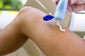 Closeup on female hand applying sunscreen on legs. Sun cream. Skincare Royalty Free Stock Photo