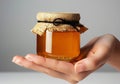 Closeup of female hand with a glass jar of honey. AI generated Royalty Free Stock Photo