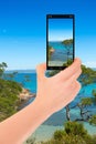 Closeup of a female hand holding a cell phone and taking a photo of an idyllic southern landscape Royalty Free Stock Photo