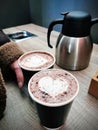 Closeup of female hand holding coffee latte with hearth shaped decorated foam on top, expresso takeaway