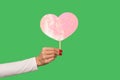 Closeup female hand holding pink heart with glitters, cute symbol of sensual feminine romantic love, greeting card Royalty Free Stock Photo