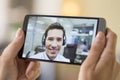 Closeup of a female hand holding a smart phone during a skype vi