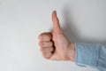 Closeup of female hand showing thumb up on white background. Well done gesture