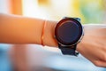Closeup of female hand wearing digital smart wrist watch with blank screen against blurred interior background Royalty Free Stock Photo
